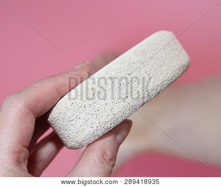Pumice Stone For Foot Care. In The Photo A Woman Hand Holds A Pumice Near The Heel Of Her Foot. Remo
