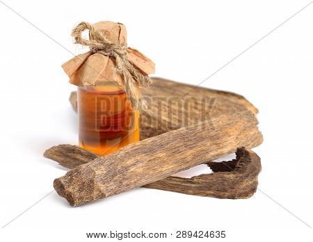 Agarwood, Also Called Aloeswood Oudh. With Essential Oil In Pharmaceutical Bottle. Isolated On White