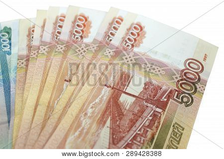 Metal Keys On A Horizontal Background Of A Variety Of Banknotes Of Five And One Thousand Russian Rub