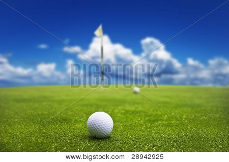 Bola de golfe no verde pronto para ser tacada no buraco
