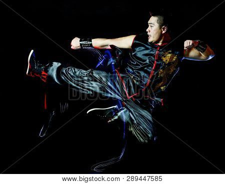 whushu chinese boxing kung fu Hung Gar fighter isolated man isolated on black background with speed light painting effect motion blur