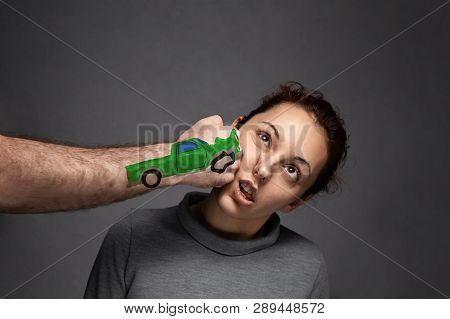 The Concept Of Car Accidents, Insurance Claims . A Woman Is Punched In The Face . On Fist Drawn Car.
