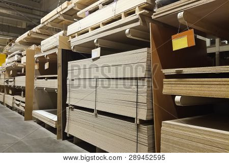 Wooden Bars At Lumber Yard Of Hardware Store. Rack Of Pre-cut Panel, Mill Wood Timber, Siding, Plywo