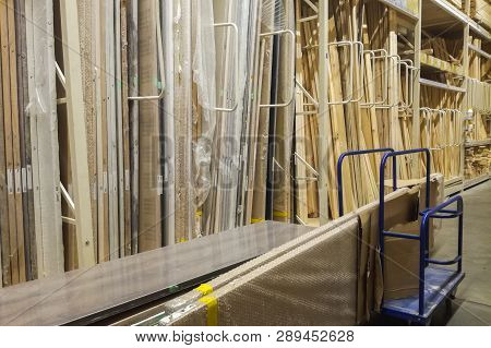Wooden Bars At Lumber Yard Of Hardware Store. Rack Of Pre-cut Panel, Mill Wood Timber, Siding, Plywo