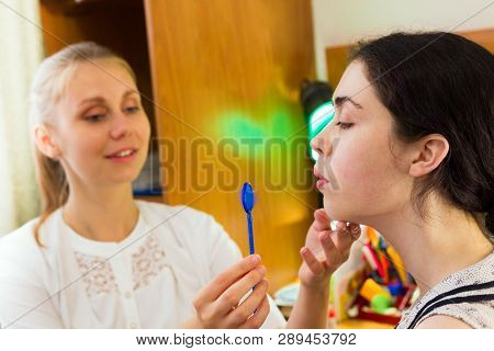 Young Woman Trains With Speech Therapy Probe In Soft Focus.