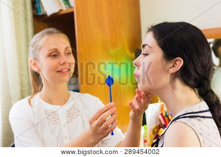 Young Woman Trains With Speech Therapy Probe In Soft Focus.