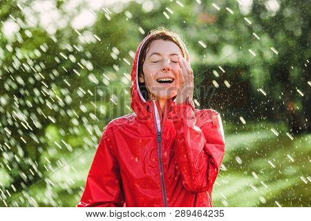 Happy Woman In Red Rain Coat In The Rain