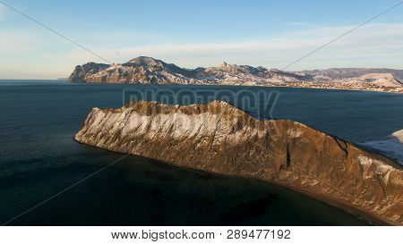 Aerial View On The Edge Of The Mountain Coast In Greenland. Aerial View On Snow Covered Mountains In