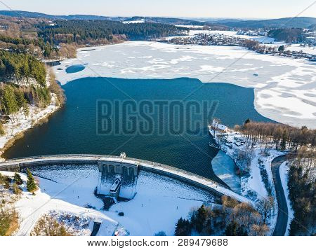 Aerial View Of The Partially Frozen Brucher Dam (bruchertalsperre) Near Marienheide In Winter.