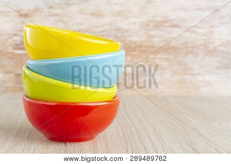 Ceramic Bowl Assorted Colors On Wooden Background