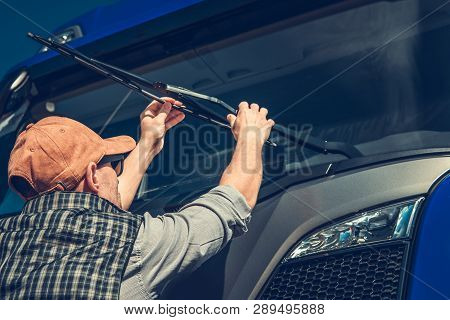 Truck Wipers Replacement By Caucasian Semi Truck Driver. Automotive Industry.