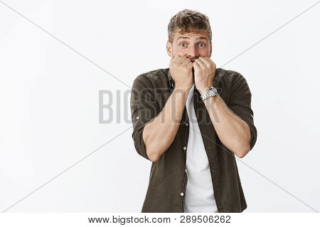 Oops. Portrait Of Intese Scared Cute Guy In Stupor Widen Eyes Biting Fingernails And Looking Worried