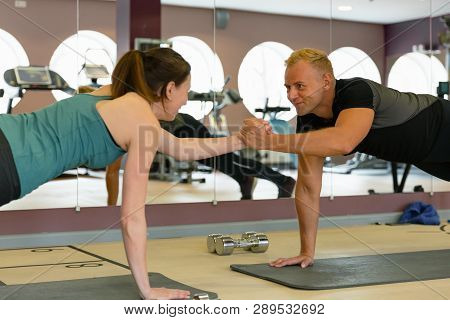 Fitness Parners In Sportswear Doing Exercises At Gym. Fitness Sport Gym Concept