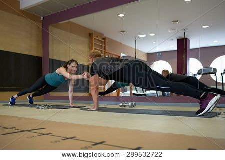 Fitness Parners In Sportswear Doing Exercises At Gym. Fitness Sport Gym Concept