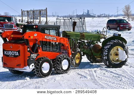 Barnesville, Minnesota, March 11, 2019: The Kubota Ssv65 Lifting A John Deere Tractor Is A Product O