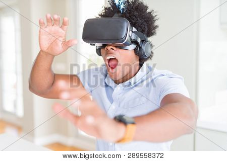 African amaerican man having fun playing with virtual reality glasses