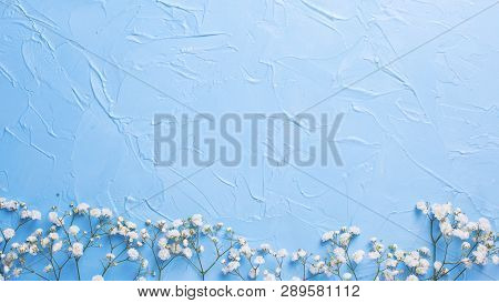 Border  From Fresh White Gypsofila  Flowers On Blue Textured Background. Top View. Flat Lay. Place F