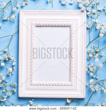 Empty Frame And  Fresh White Gypsofila  Flowers On Blue Textured Background. Top View. Flat Lay. Pla