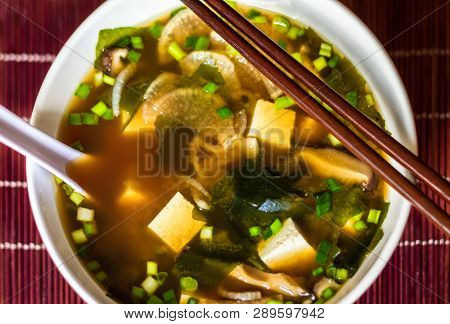 Japanese Traditional Miso Soup With Tofu, Spring Onions, Wakame Seaweed, Served In White Bowl With S