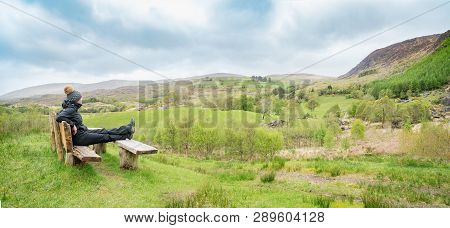 Girl Sitting On The Bench And Looking At The Beautiful Spring Landscape In Kenmare