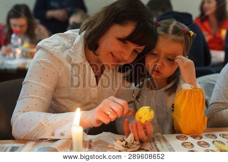 Lviv, Ukraine - March 11, 2018. Mom And Daughter Paint Easter Eggs At The Table
