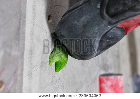 Rocky Shoe On A Tiny, Scanty Snare Stands With The Tip Of The Sock In Close-up On The Climbing Wall 