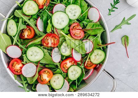 Fresh Salad With Green Leaves Of Arugula, , Spinach, Beets, Radish, Cucumber And Tomato On A Gray St
