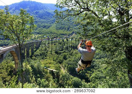 A Man Crosses Over A Long Cable Car Over A Mountain And Forest Across The Tiara River In Montenegro 