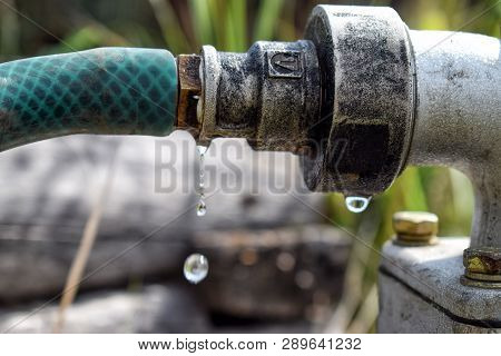 Falling Drop From Metal Pipe With Water Close Up