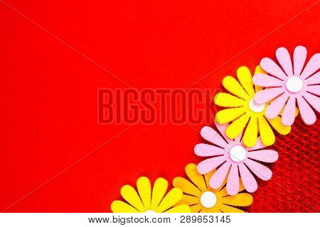 Birthday Gift Card With Red  Ribbon Decoration And Multicolor Flowers Laying On Red Background