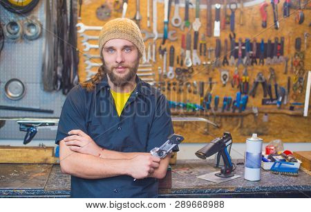 Blue Eyed Beraded Guy With A Tool In The Workshop