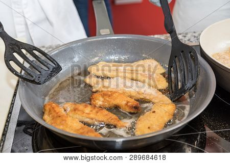 In A Frying Pan, Chef Roasts Breaded Meat - Close-up