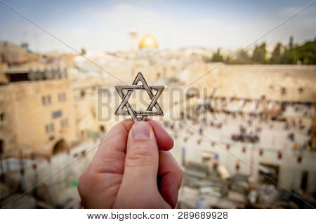 Jerusalem, Israel. February 15, 2019. Hand Holding A Star Of David, A Jewish Religious Symbol Agains