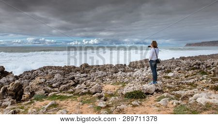 Woman, Girl Takes Pictures On The Beach Of The Atlantic Ocean