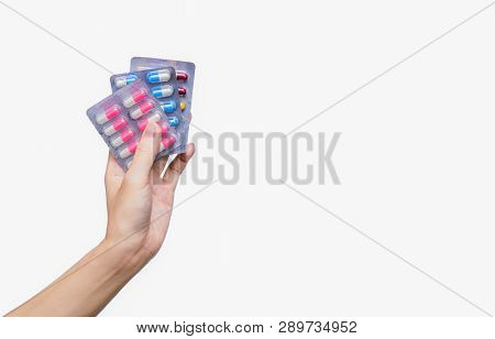 Asian Adult Hand Holding Antibiotics Drug In Blister Pack. Woman Hand Hold Three Pack Of Capsule Pil