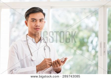 Smart Male Doctor Using Tablet Computer Looking Camera With White Gown Suite Wearing Stethoscope On 