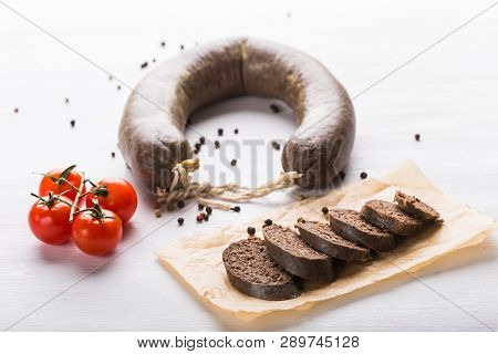 Food, Cuisine And Horsemeat Concept - Close Up Of Meat Sausage With Tomatoes And Pepper On Kraft Pap