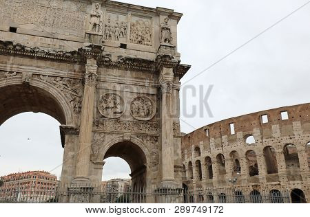Big Triumphal Arch Of The Emperor Constantine In Rome In Italy And The Great Coloseeo In The Backgro