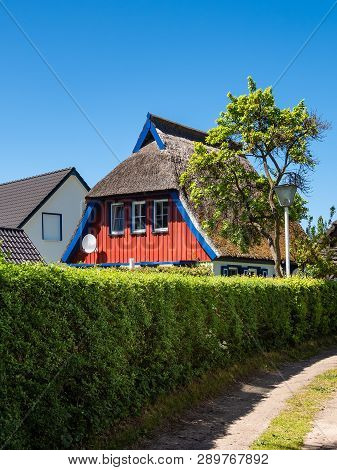 Building, Trees And Blue Sky In Wieck, Germany.