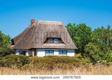 Building, Trees And Blue Sky In Wieck, Germany.