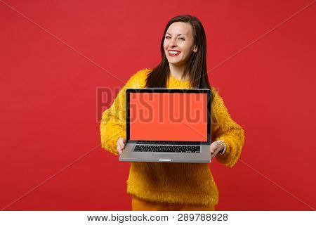 Charming Young Woman In Yellow Fur Sweater Holding Laptop Pc Computer With Blank Empty Screen Isolat