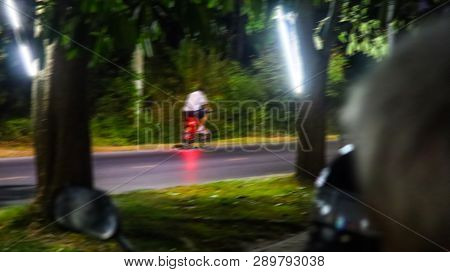 Blurred Images Of Men Wearing White Shirts Are Cycling Fast To Exercise