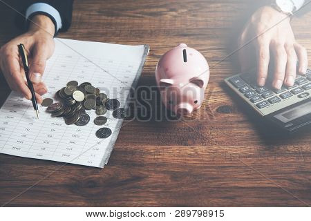 Man Hand Coins With Piggy Bank And Calculator
