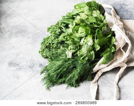 Healthy Green Vegan Ingredients For Cooking. Various Herbs And Keil In Textile Bag On Grey Backgroun