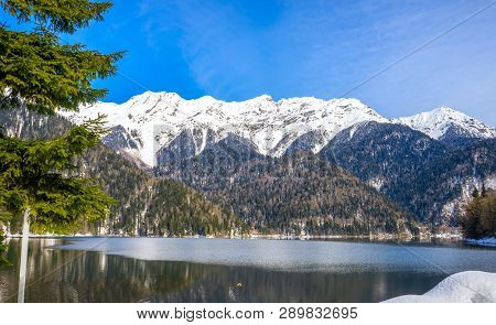 Mountains Covered With Forests And Snow On The Shores Of A Beautiful Mountain Lake