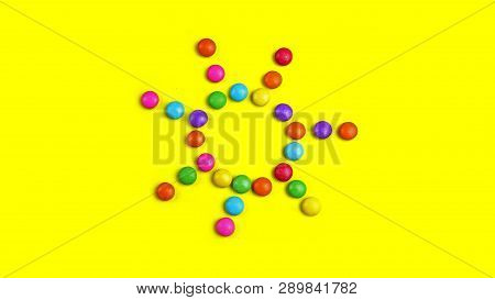 Colorful Chocolade Smarties On The Yellow Background . It Is Sun Shape.