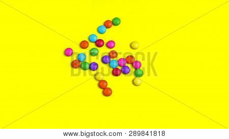 Colorful Chocolade Smarties On The Yellow Background.