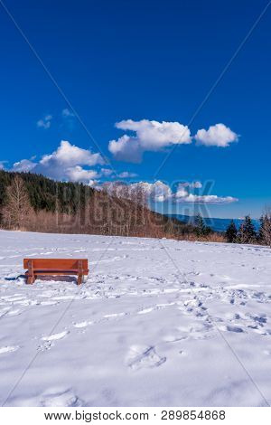 A park bench with gorgeous view at mountains and blule sky with white clouds, British Columbia, Canada.