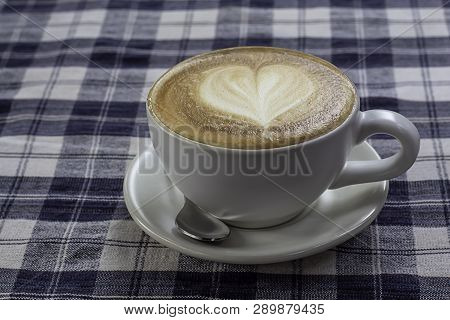 Hot Coffee Espresso Topped With A Heart-shaped Milk In White Glass On The Table With Chintz Scott.