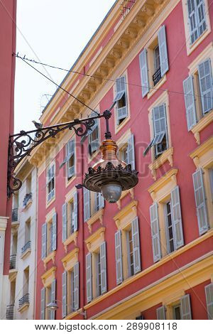 Nice, France - April 18 2017. Beautiful Street Lantern In Nice, France. Red Facade Of Old Houses In 